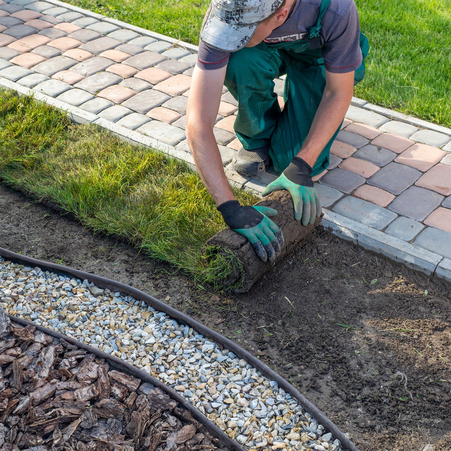 Gardener laying turf for new lawn